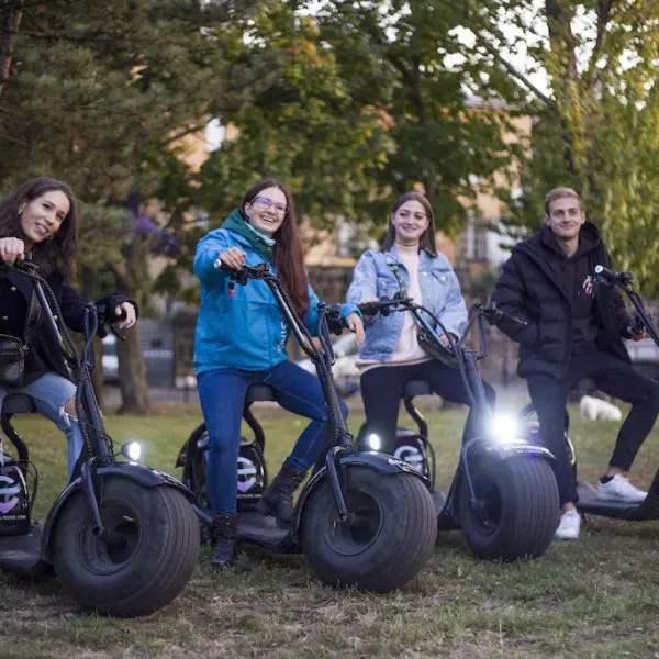 Young tourists on monsterollers in jackets