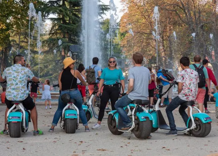 People on e-scooters in front of the Musical Fountain at Margaret Island