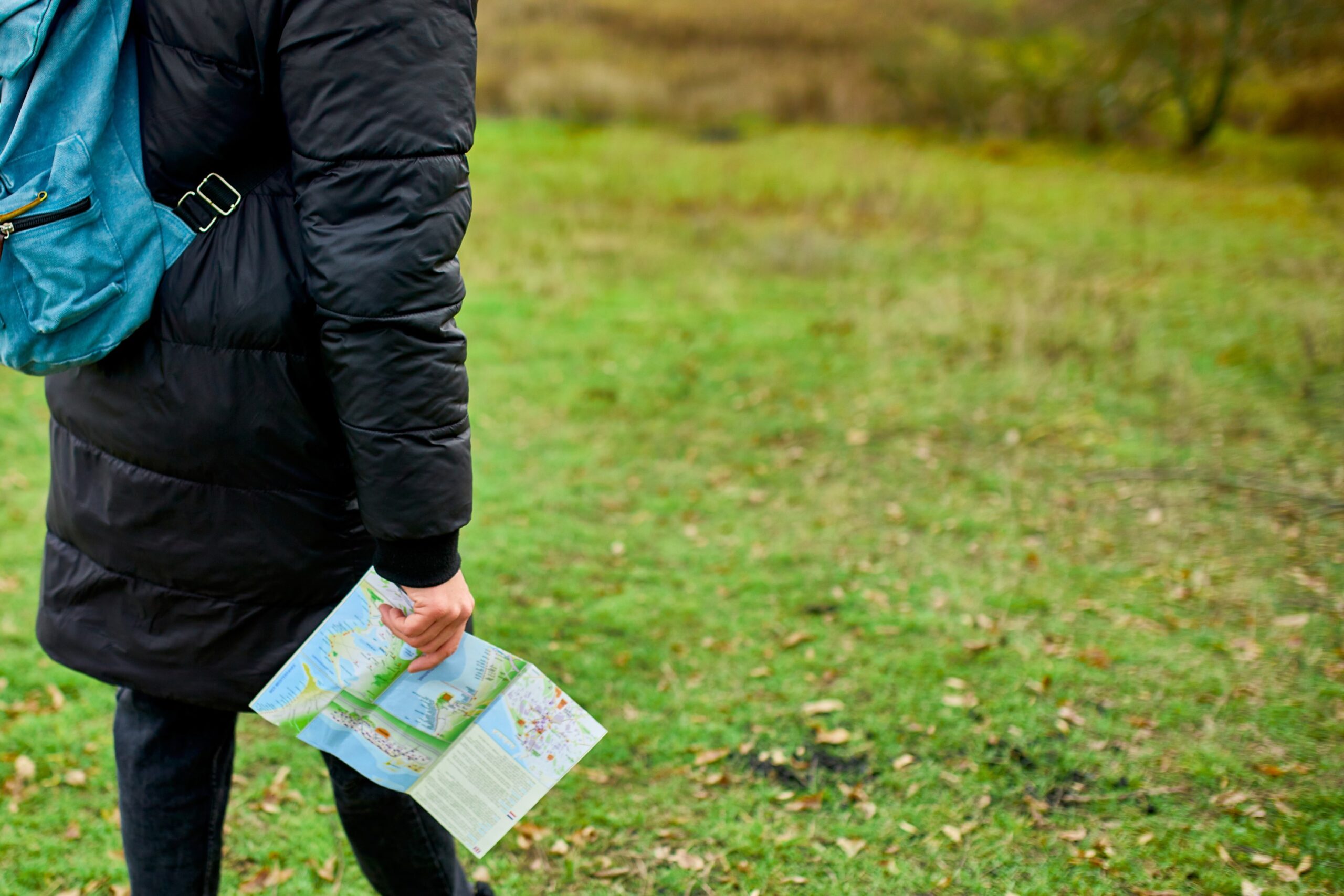 Traveller with backpack and map in hand in the wilderness