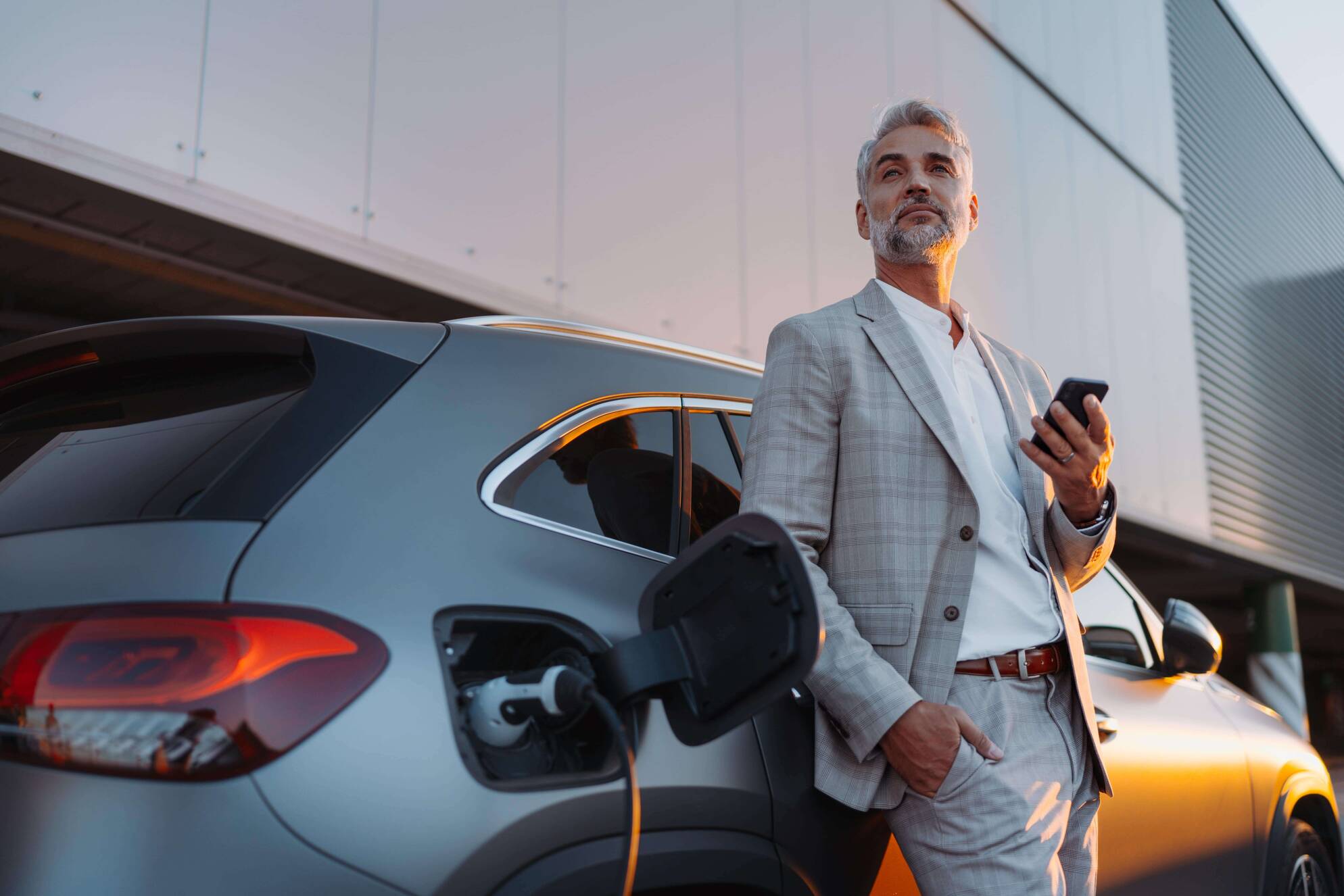 Man charging his electric car at a station