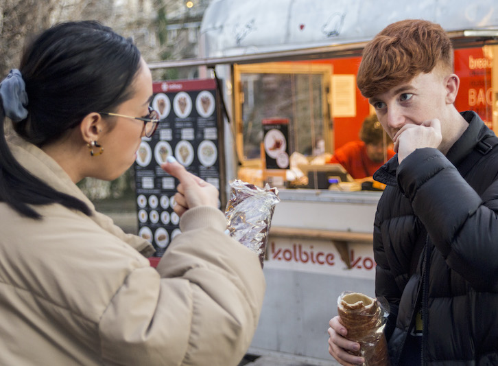 Guests try kürtőskalács for the first time on Christmas tour by E-Magine Tours.